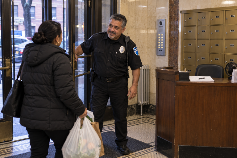 ProGuard officer helping a resident in the lobby of a pre-war apartment building
